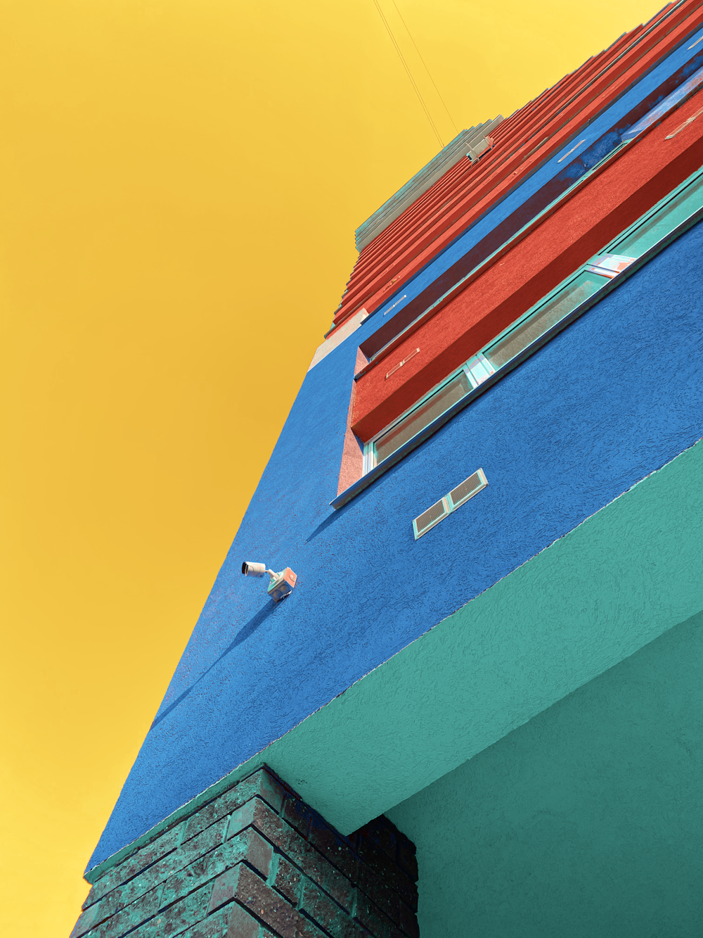 a red and blue building with a yellow sky in the background
