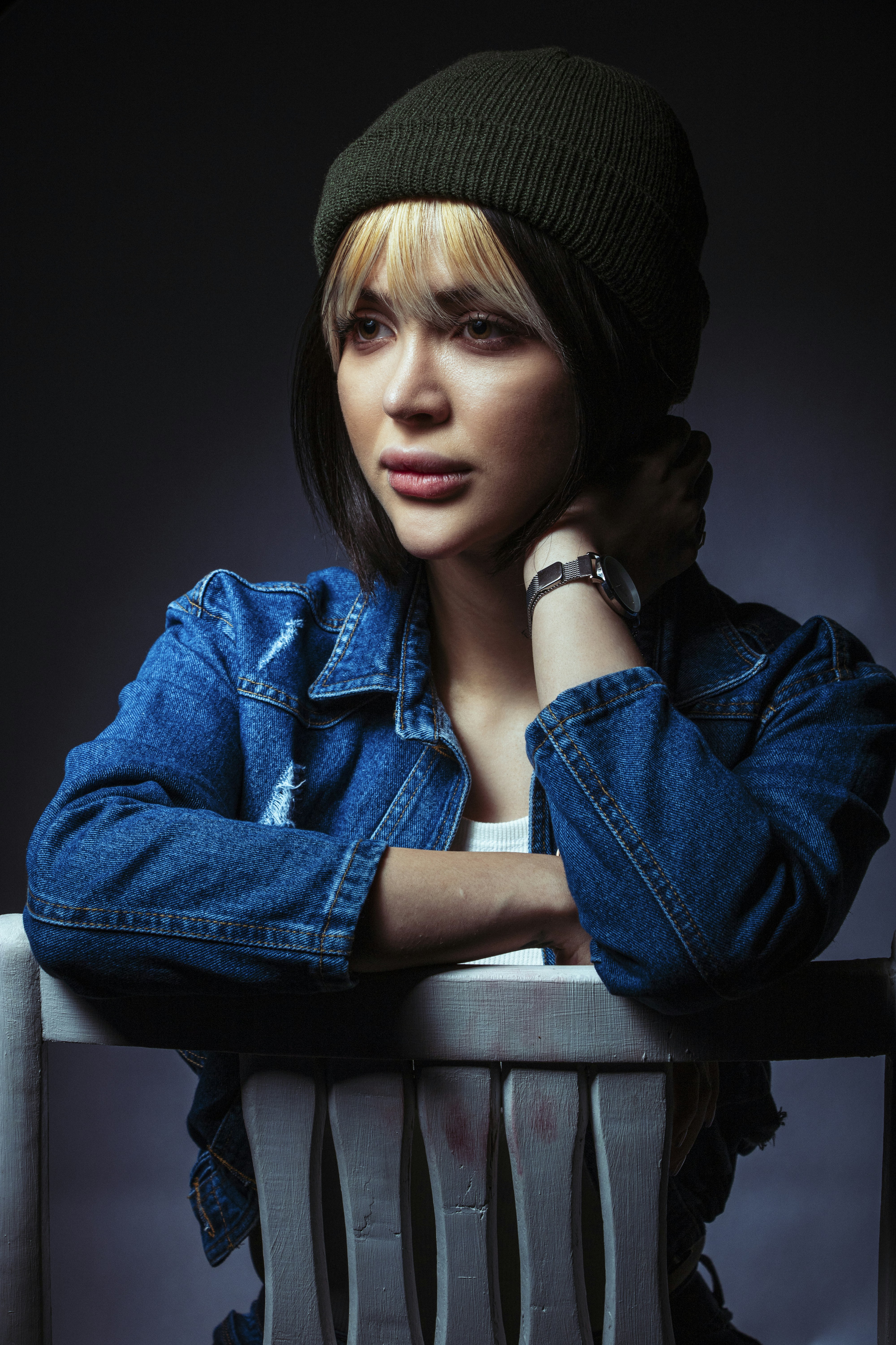 wanita dalam jaket denim biru dan topi rajutan hitam