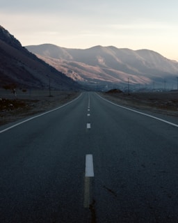 A serene landscape with an empty road leading into the horizon, symbolizing a journey of solitude.