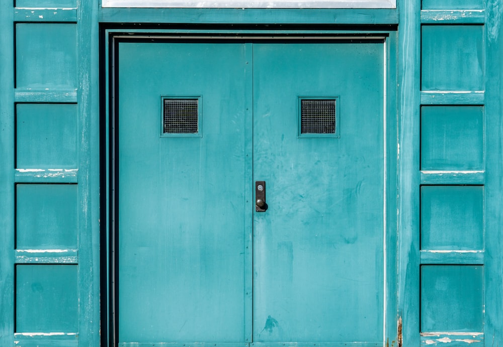 Porte en bois bleu avec levier de porte en acier noir