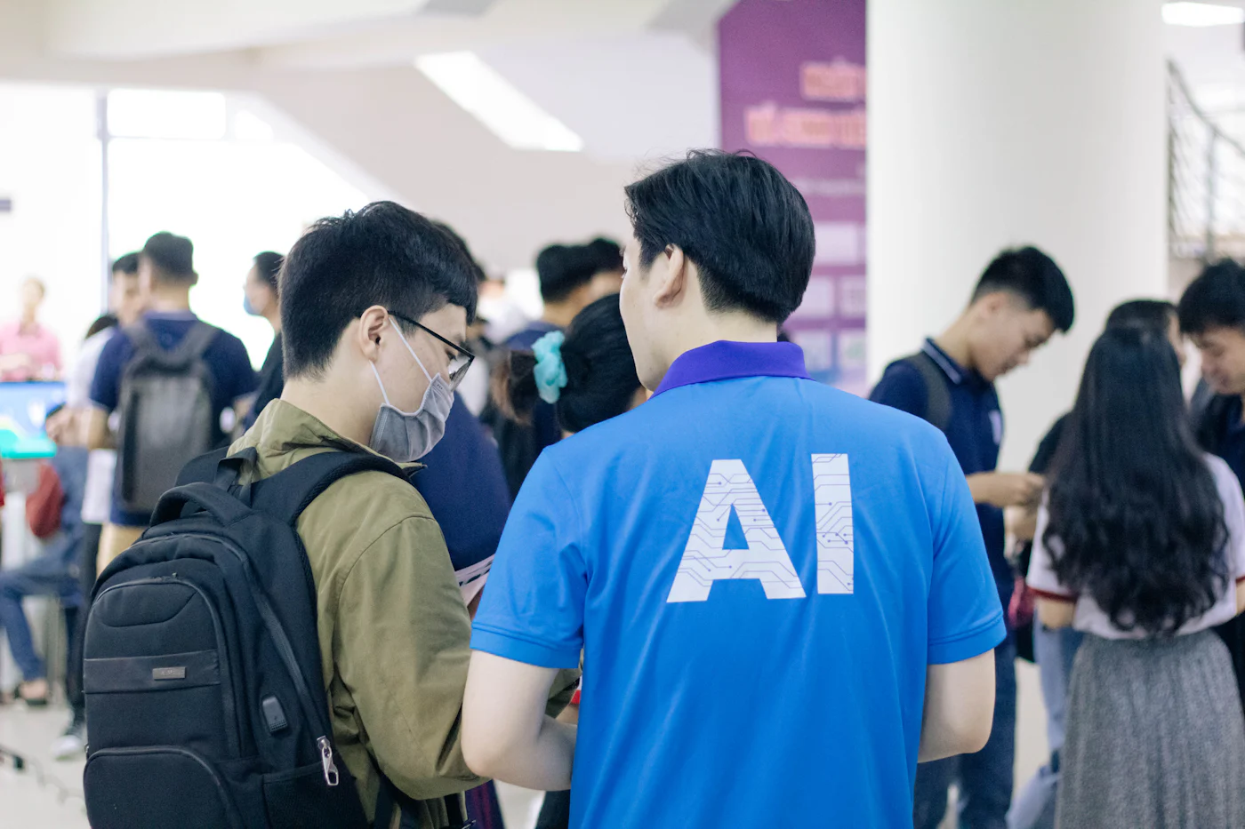 Equipo de oficina trabajando junto a pantallas con interfaces de inteligencia artificial