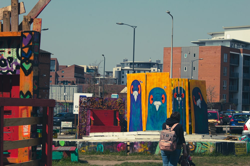 woman in black jacket standing in front of blue and yellow wall