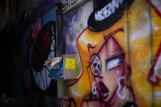 Colorful street art mural featuring the $wif hat and the slogan 'the hat stays on'