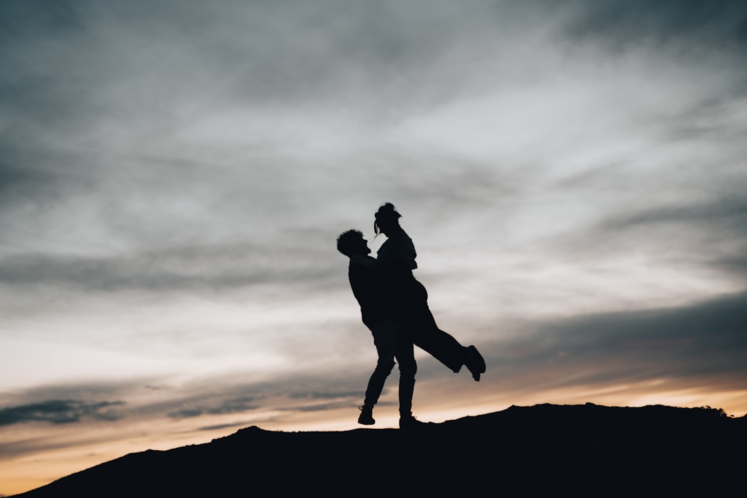 silhouette of man and woman kissing during sunset