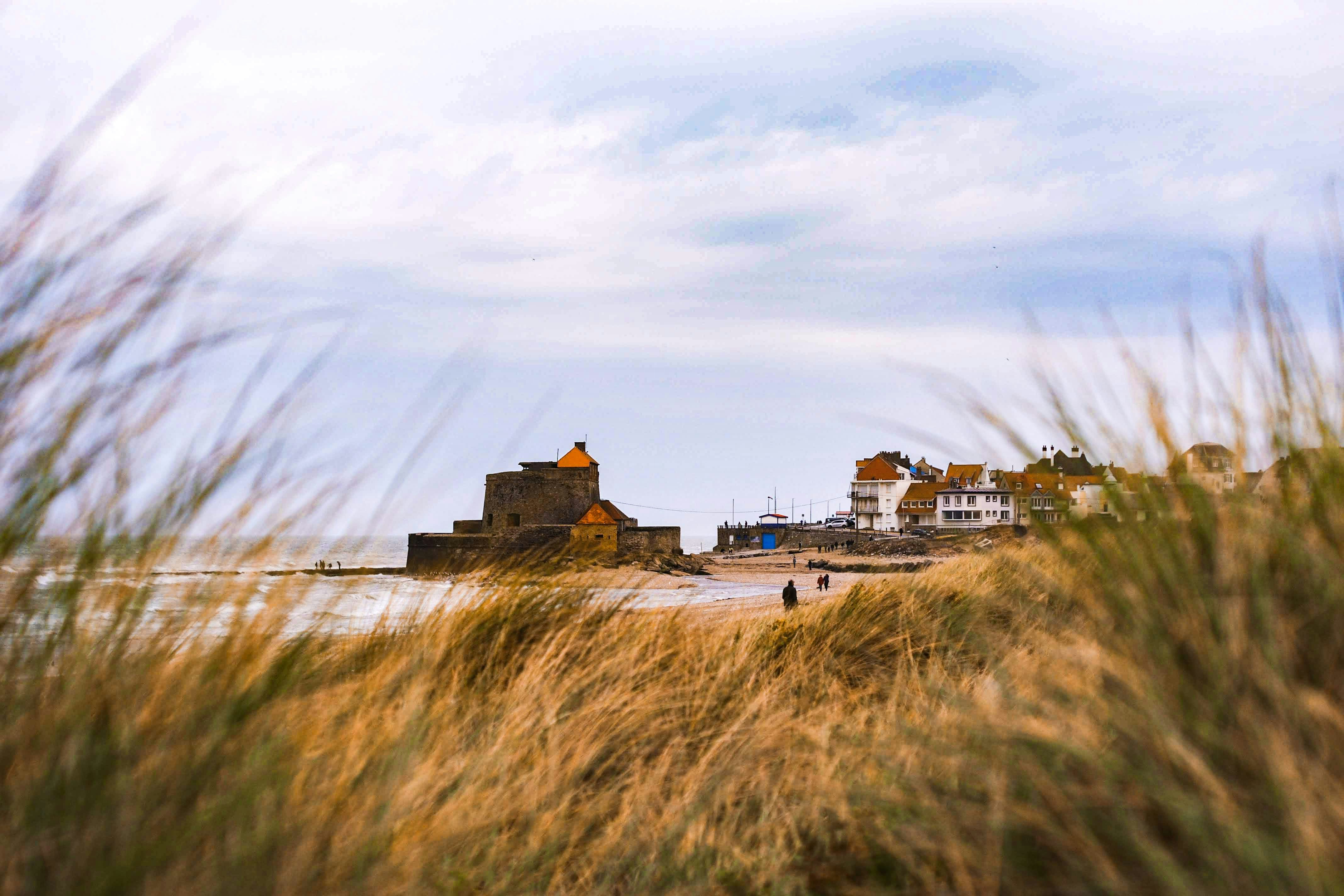 Bâtiment en béton brun et blanc près d’un plan d’eau pendant la journée