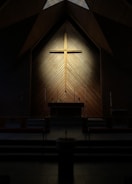 A peaceful church interior with warm yellow lighting and crosses.