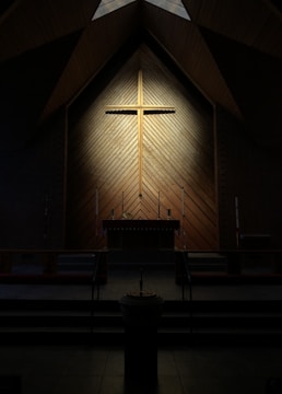 A peaceful church interior with warm yellow lighting and crosses.