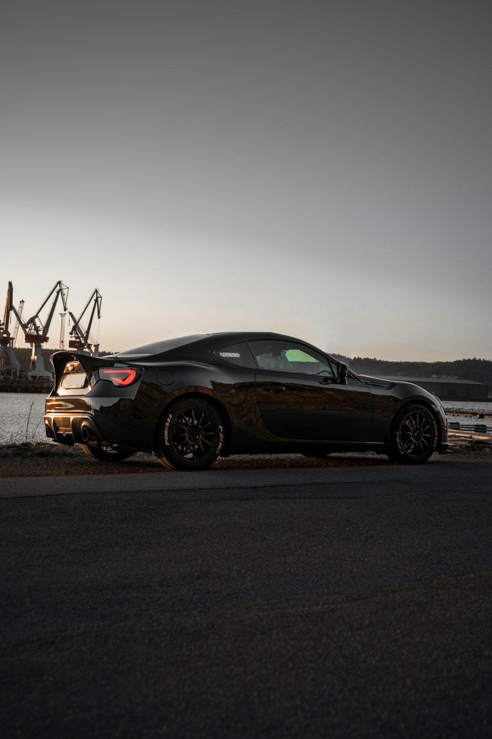 black coupe on gray asphalt road during daytime