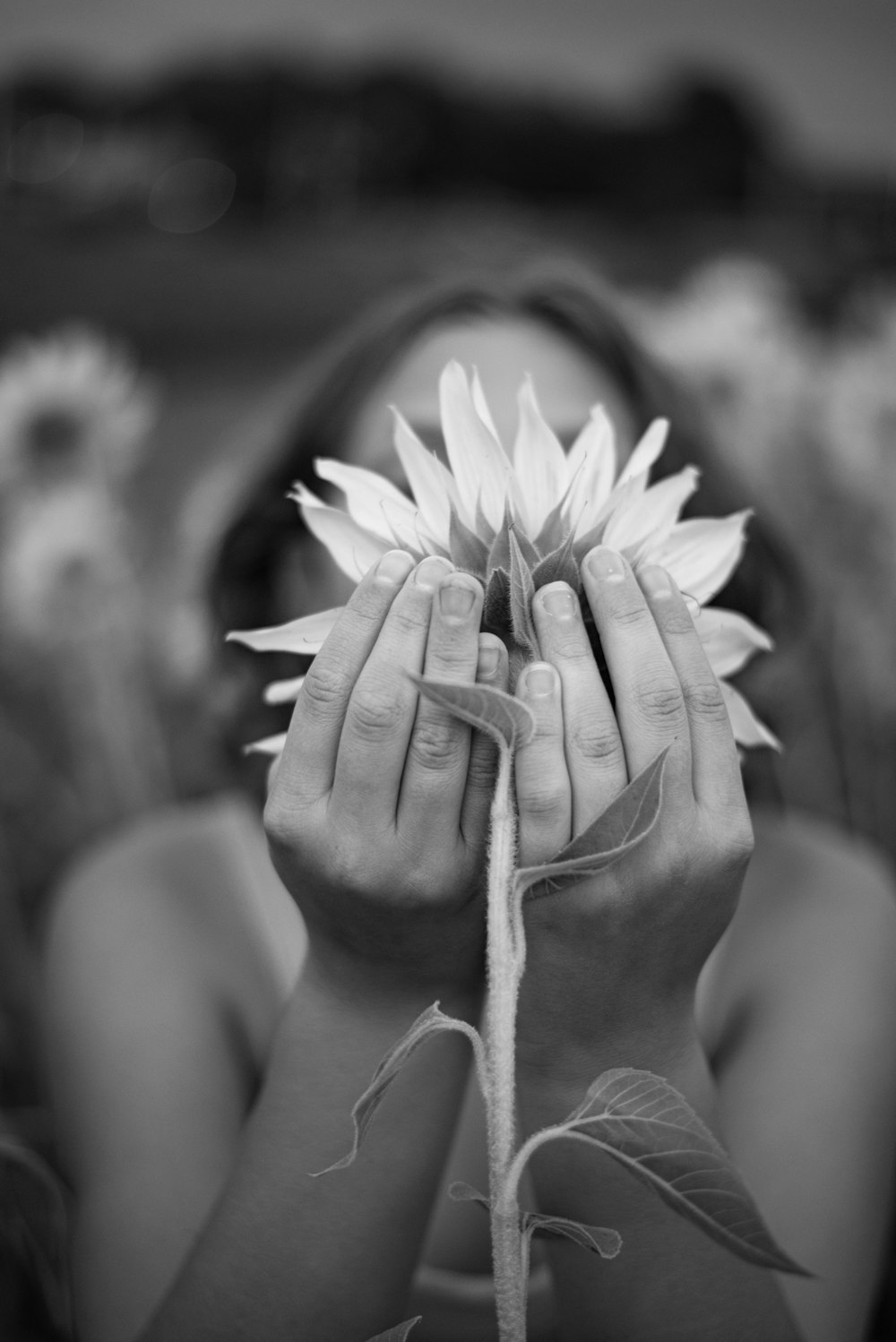 grayscale photo of woman holding flower