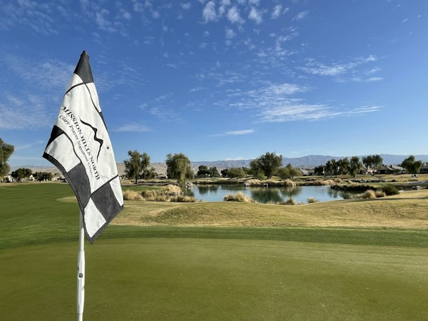 A golf green and flagstick at sunset on a desert course in the Las Vegas valley