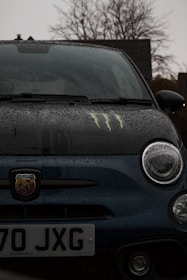 A close-up of a car with rain droplets, symbolizing protection against weather damage.
