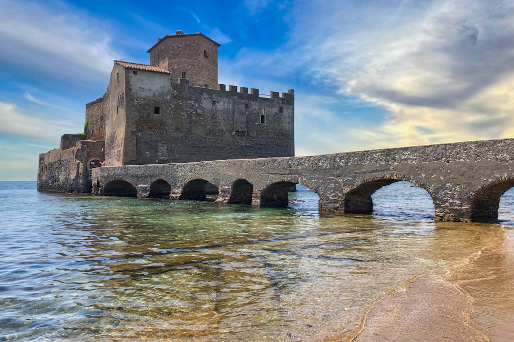 Costruzione in cemento marrone sull'acqua sotto il cielo blu durante il giorno