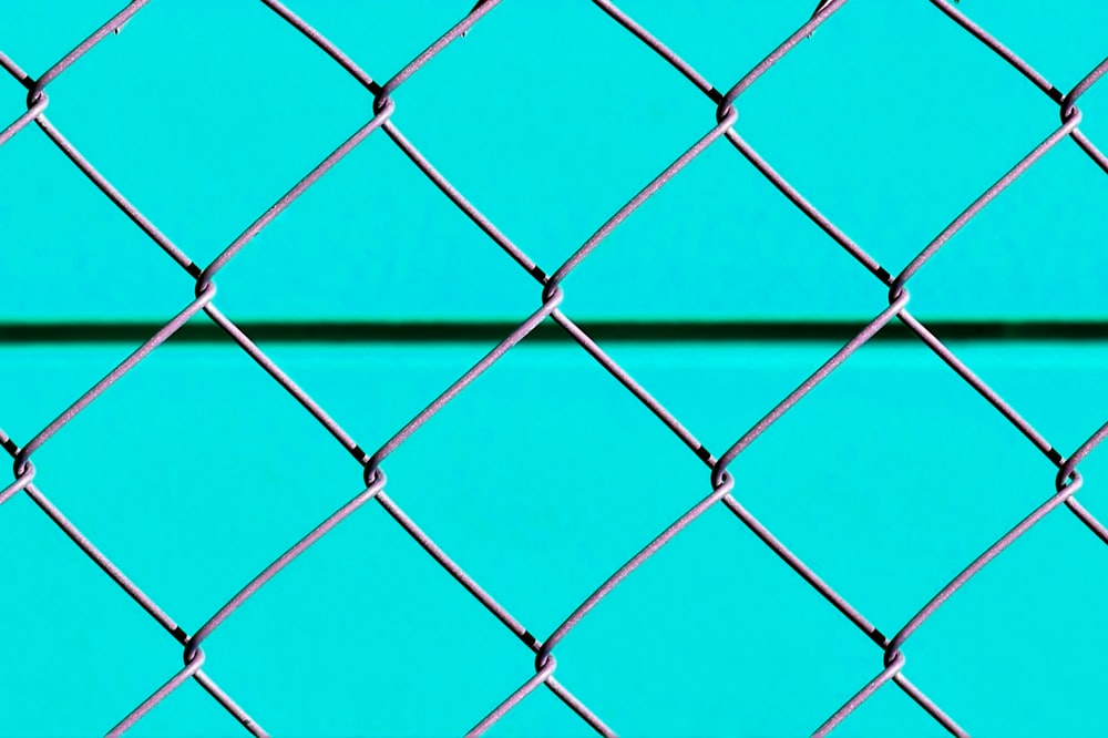 チェーン・リンクの塀が付いている青い金属の塀
