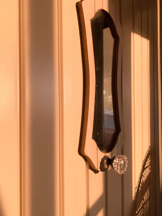 A sturdy vintage door with classic iron handles bathed in warm sunlight.