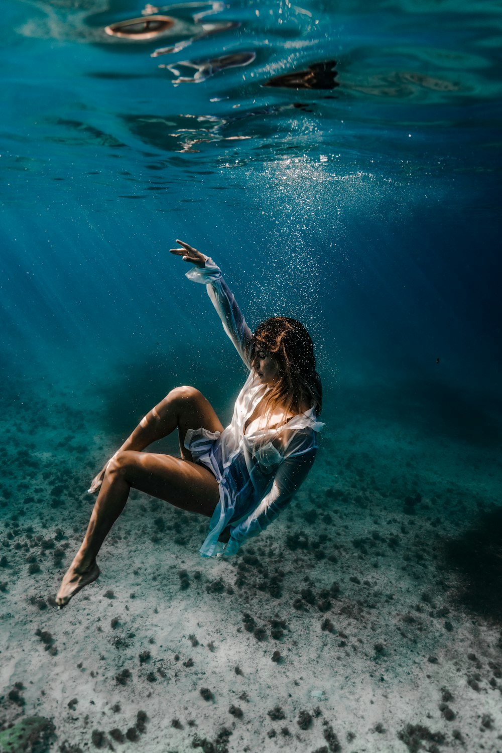 woman in blue and white bikini lying on water