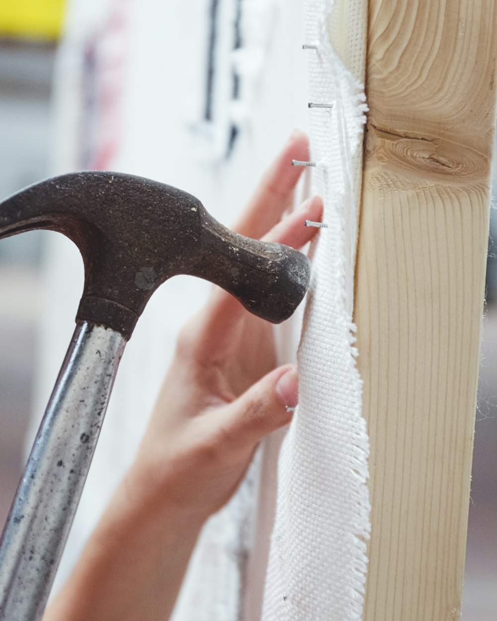 person holding black and silver claw hammer