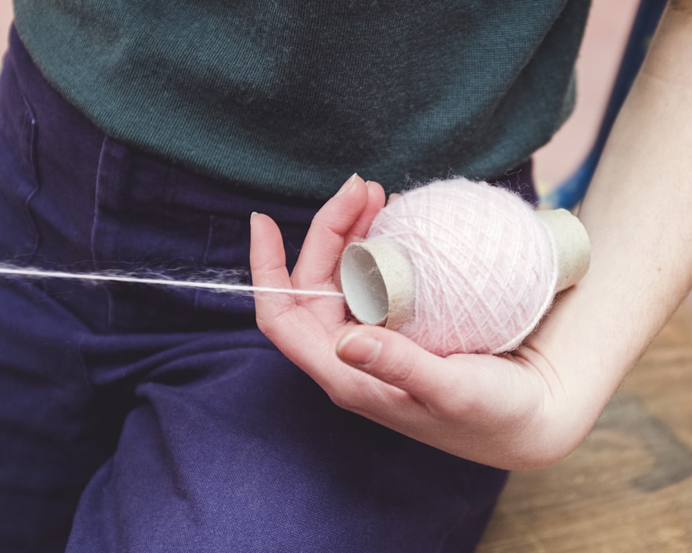 person holding white yarn ball