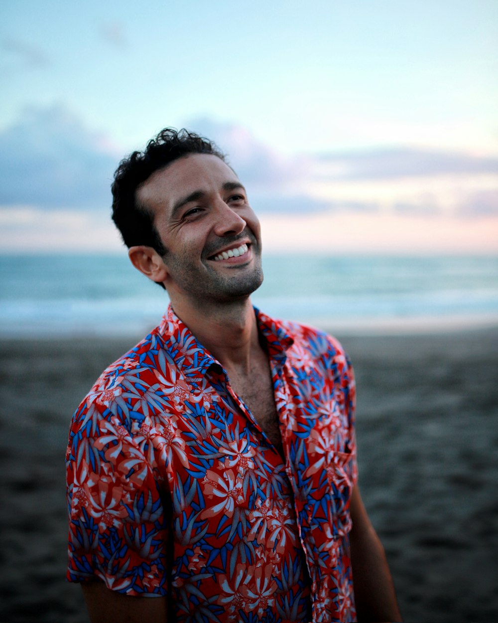 Hombre en camisa abotonada azul y naranja sonriendo