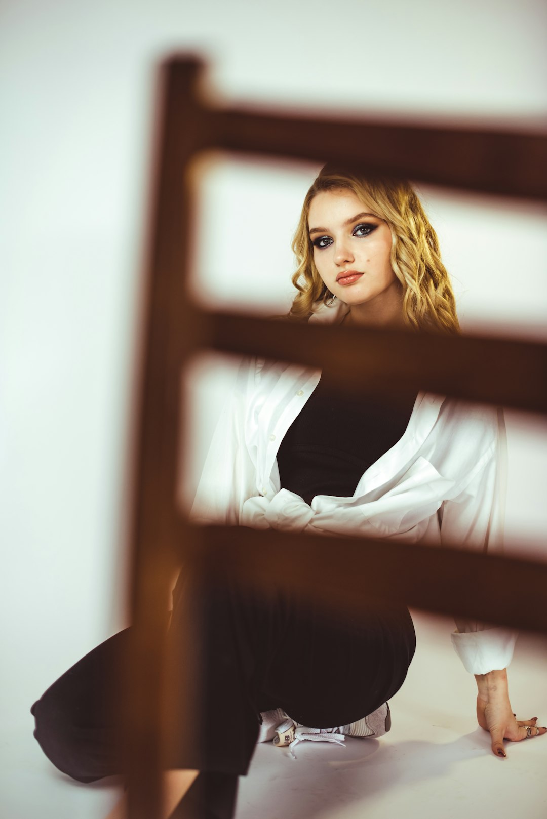 woman in white long sleeve shirt sitting on brown wooden chair