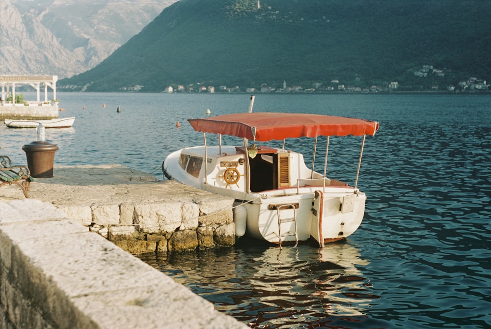 white and red boat on body of water during daytime