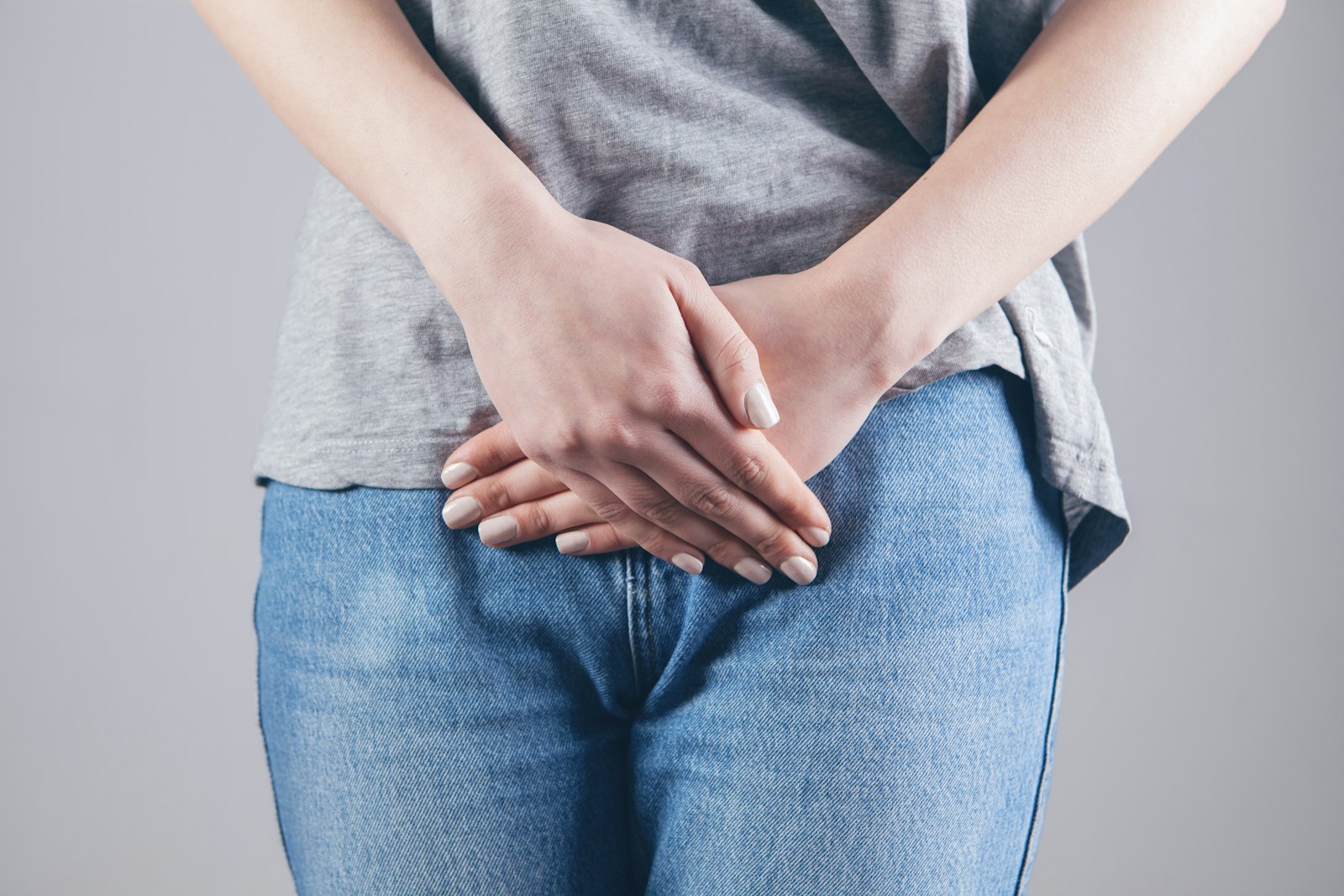 Person fasst sich von vorne an den Bauch – beim Reizdarm wechseln Schmerzen, Blähungen und Stuhlunregelmäßigkeiten