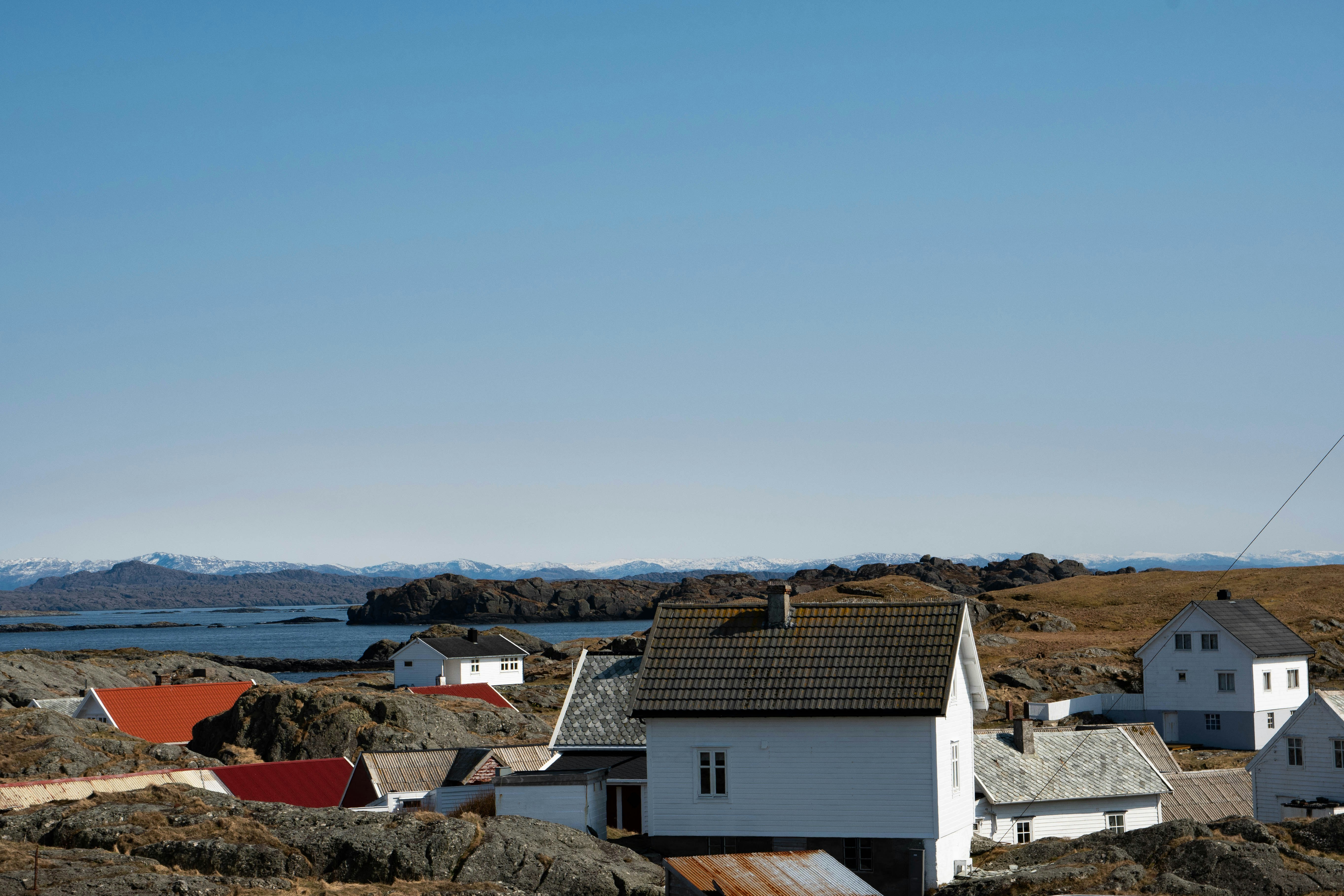 white and brown concrete houses near body of water during daytime