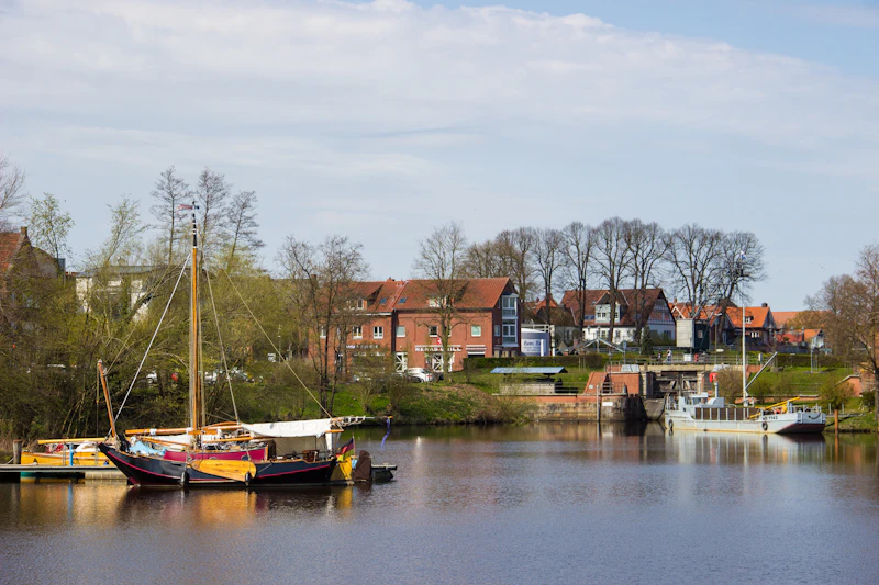 brown and white boat on river near houses during daytime