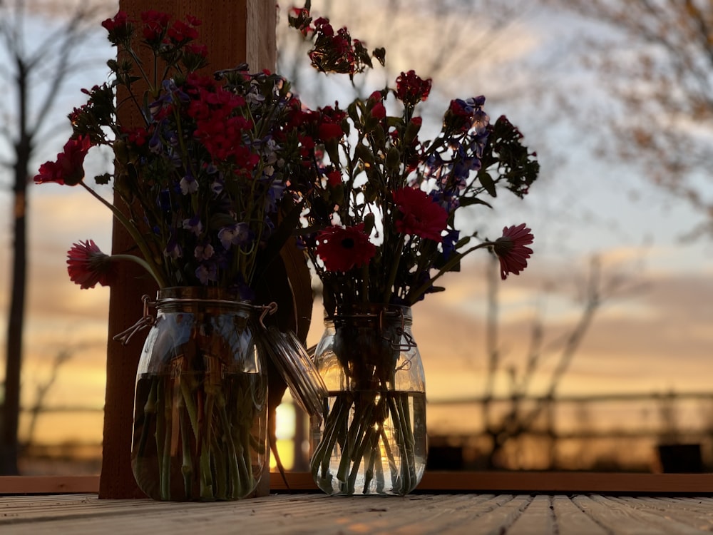 red and yellow flowers in clear glass vase