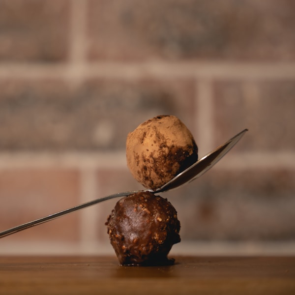 three brown round fruits on brown wooden table