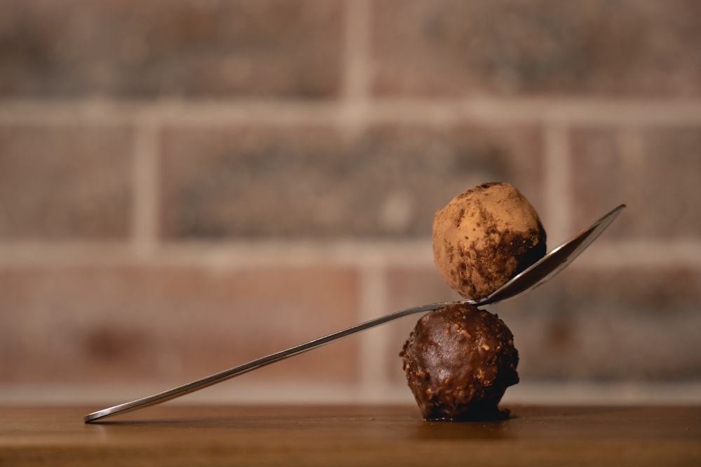 tres frutas redondas marrones sobre una mesa de madera marrón