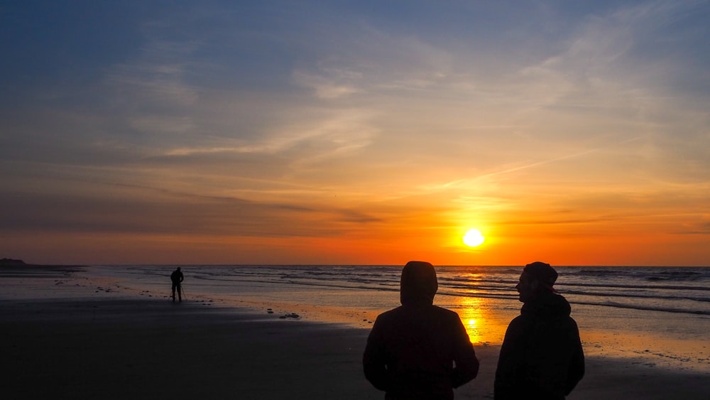 silhouette of people on beach during sunset