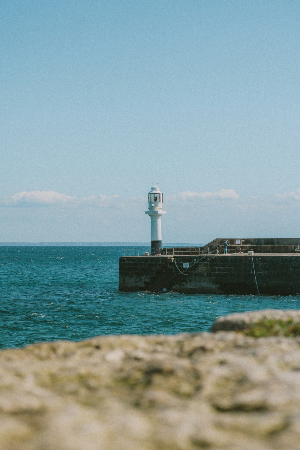 a light house sitting on top of a pier next to the ocean