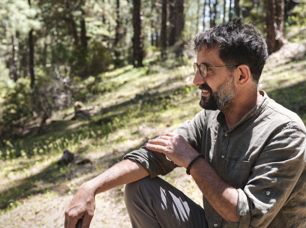 man in grey button up shirt sitting on ground