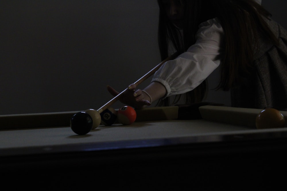 woman in white long sleeve shirt playing billiard