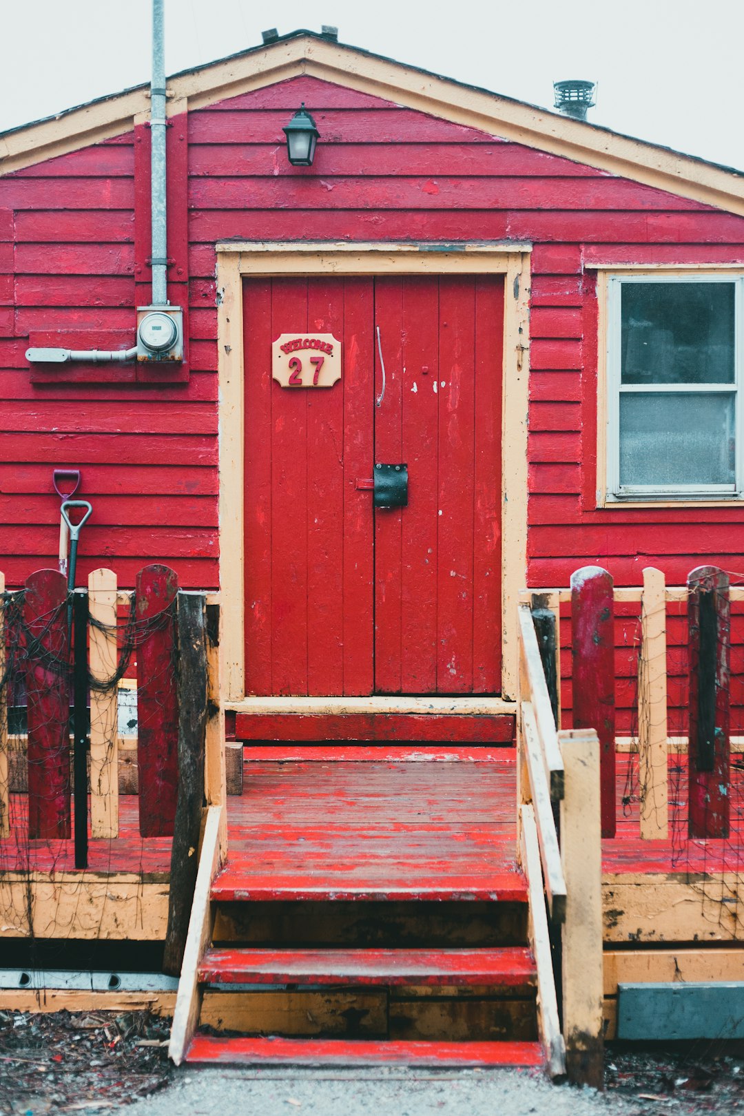 brown wooden ladder leaning on red wooden door