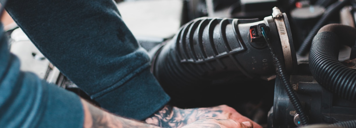 person in blue denim jeans and black and white adidas sneakers riding on black motorcycle