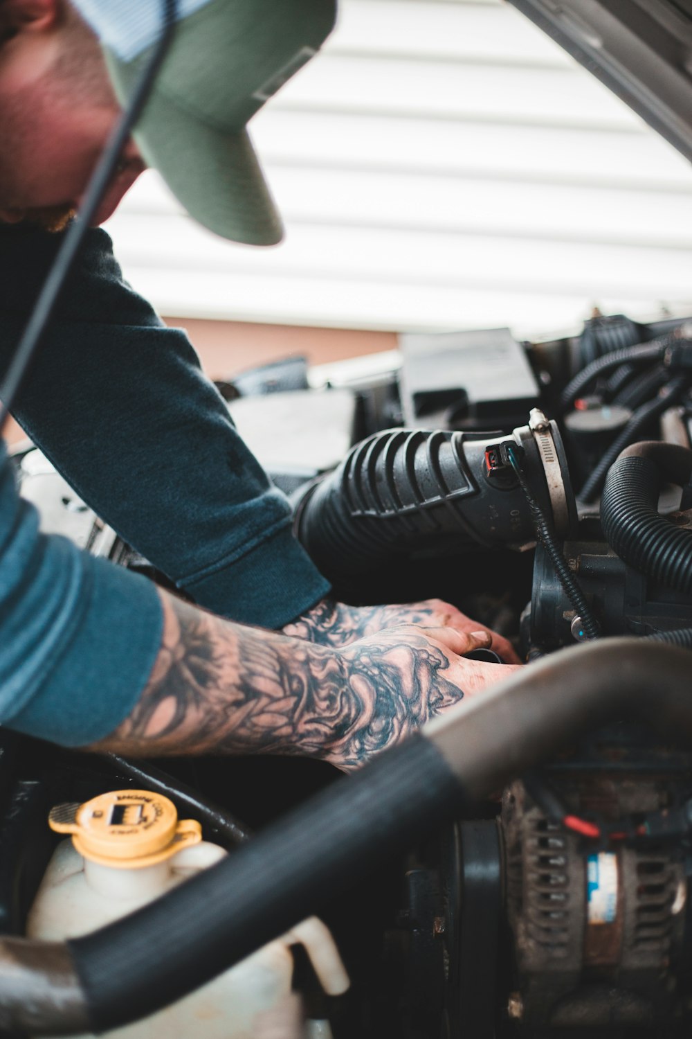 ブルーデニムジーンズと黒と白のアディダススニー�カーを履いた人物が黒いバイクに乗っている