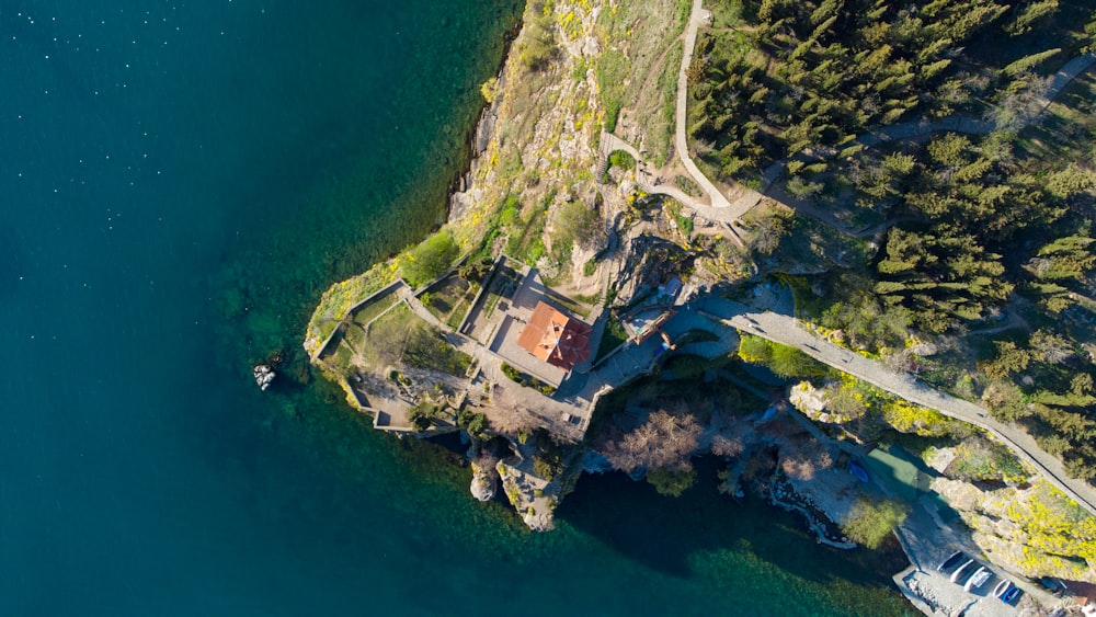 aerial view of brown and green mountain beside body of water during daytime