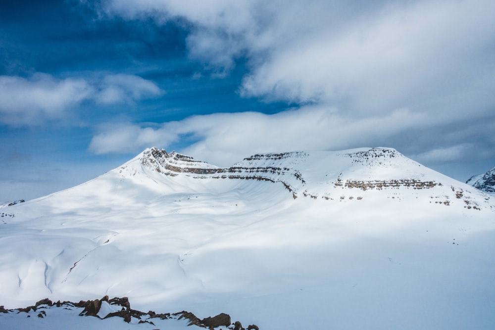 snow covered mountain under cloudy sky during daytime