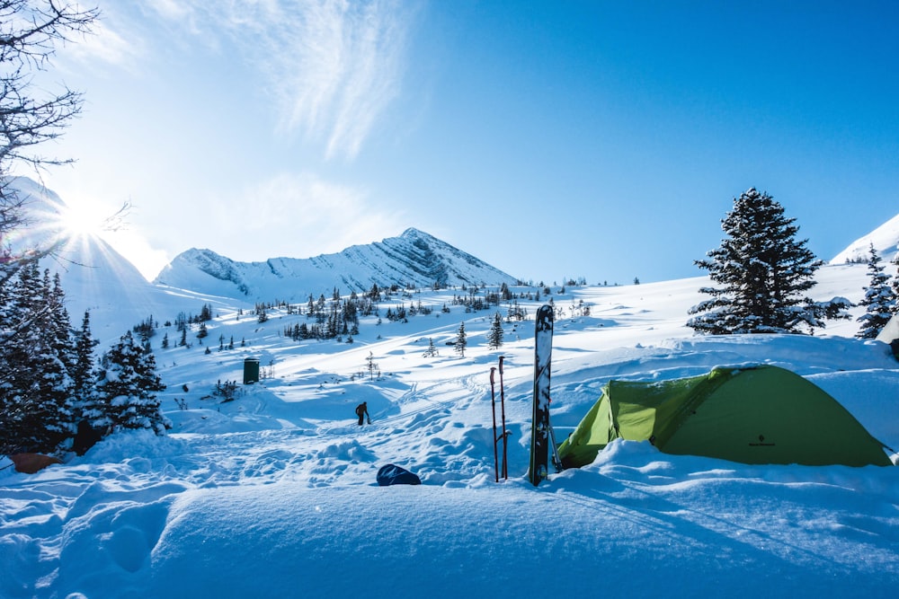 green tent on snow covered ground during daytime