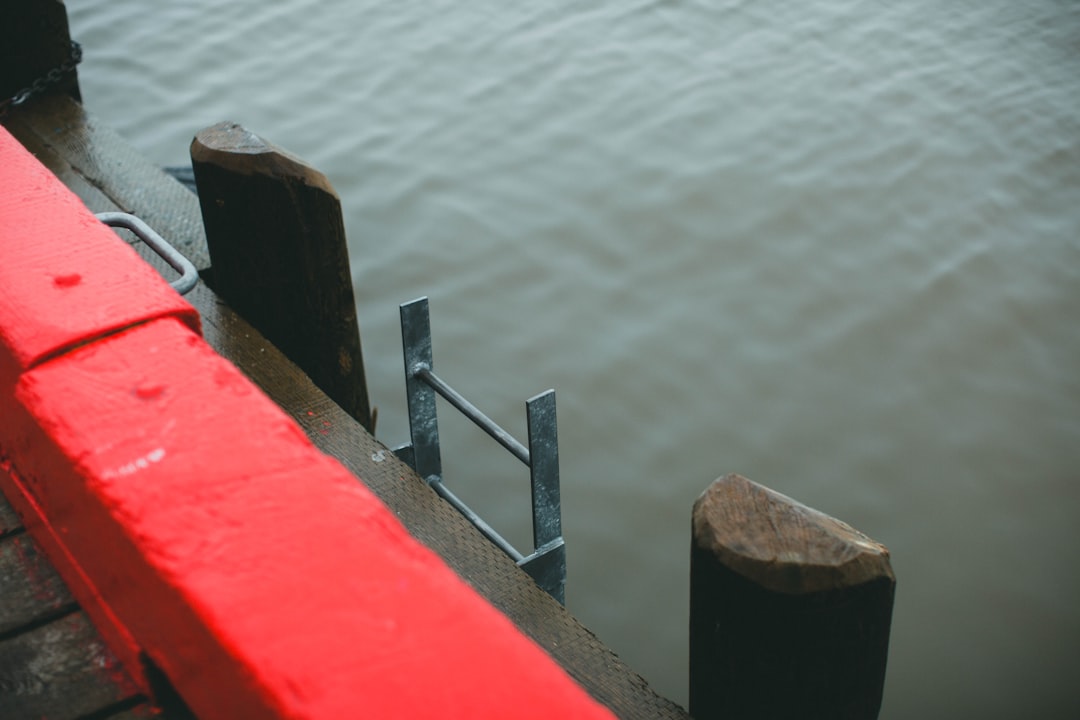 red and brown wooden dock on body of water during daytime