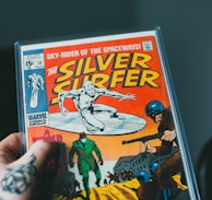 a person holding a comic book in their hand
