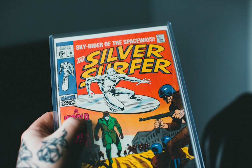 a person holding a comic book in their hand