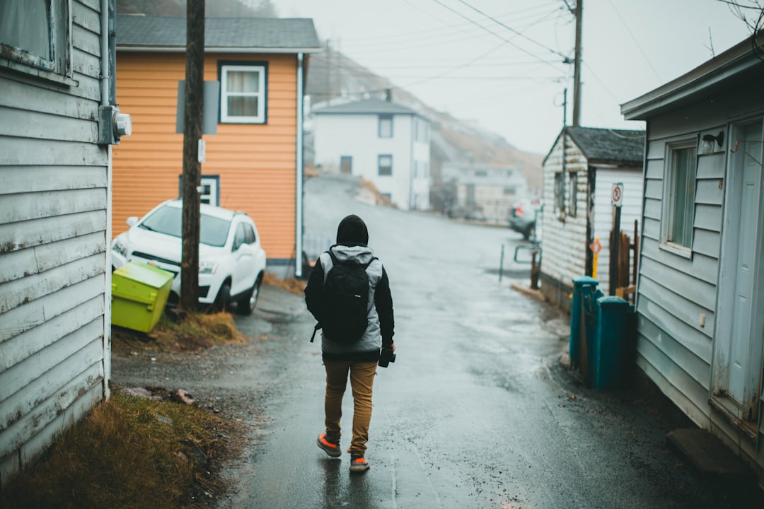 man in black jacket walking on street during daytime