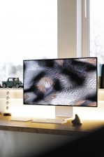 black flat screen computer monitor on brown wooden desk