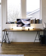silver imac on brown wooden table