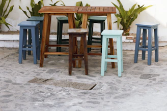 Bright plastic patio stools arranged around a small outdoor table, perfect for casual gatherings.