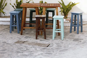 Bright plastic patio stools arranged around a small outdoor table, perfect for casual gatherings.