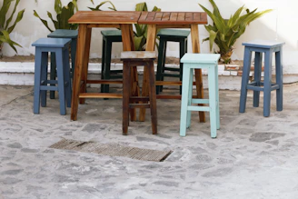 Colorful plastic patio stools arranged around a small garden table.