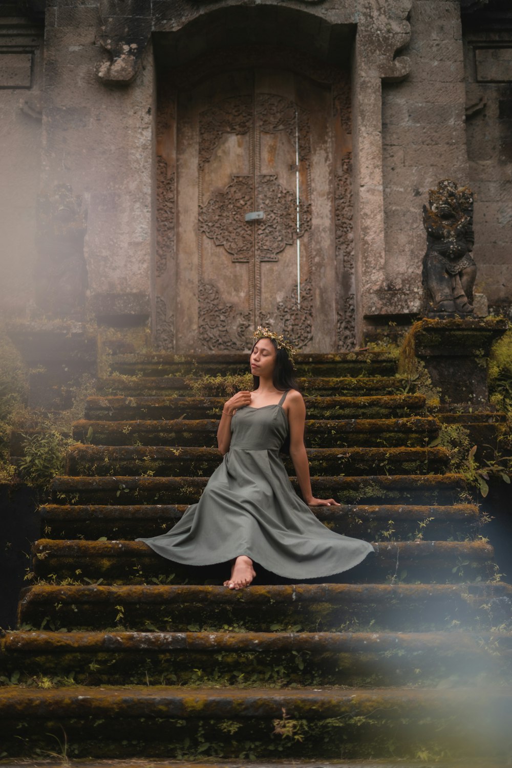 woman in green tube dress standing on stairs